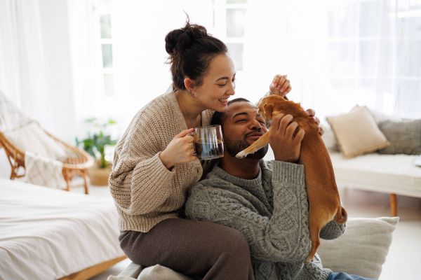 happy couple at home holding kitten