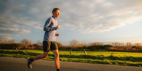 Man running on street in nature
